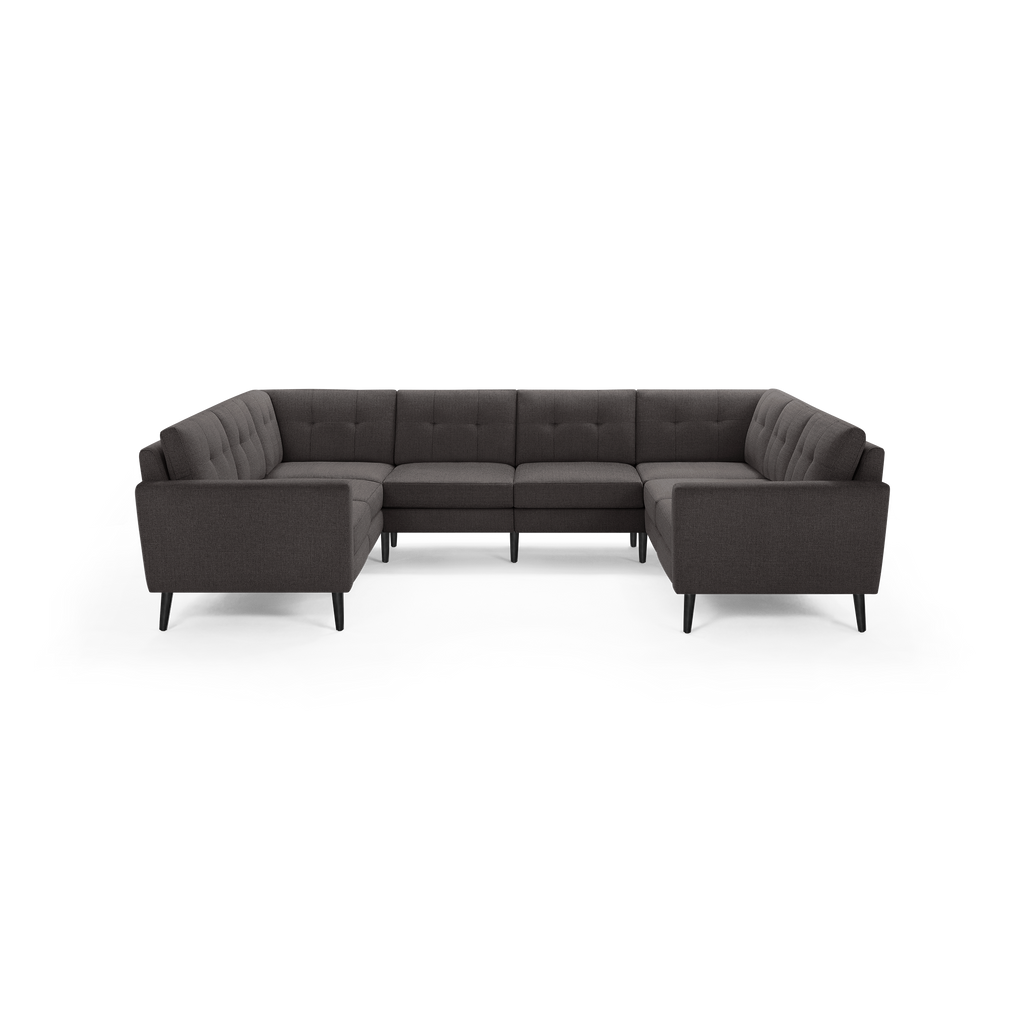 U-shaped dark gray fabric sectional sofa with tufted cushions, padded arms, and black tapered legs.