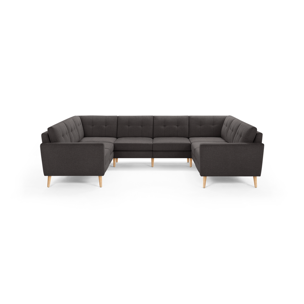Dark gray fabric sectional sofa with tufted back cushions and light wooden legs, arranged in a U-shape.
