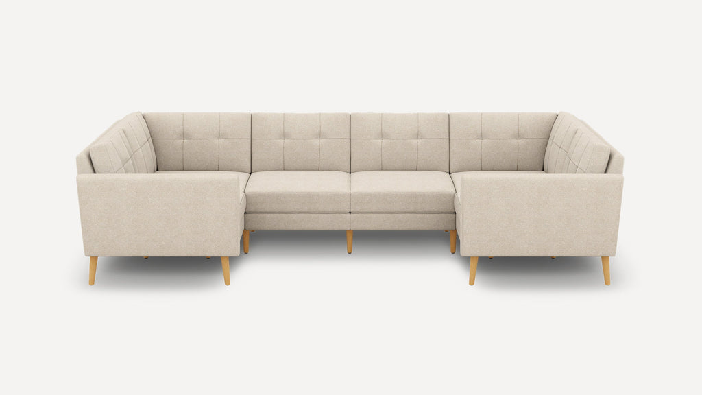 Beige U-shaped sectional sofa with tufted back cushions and wooden tapered legs, designed for spacious seating.