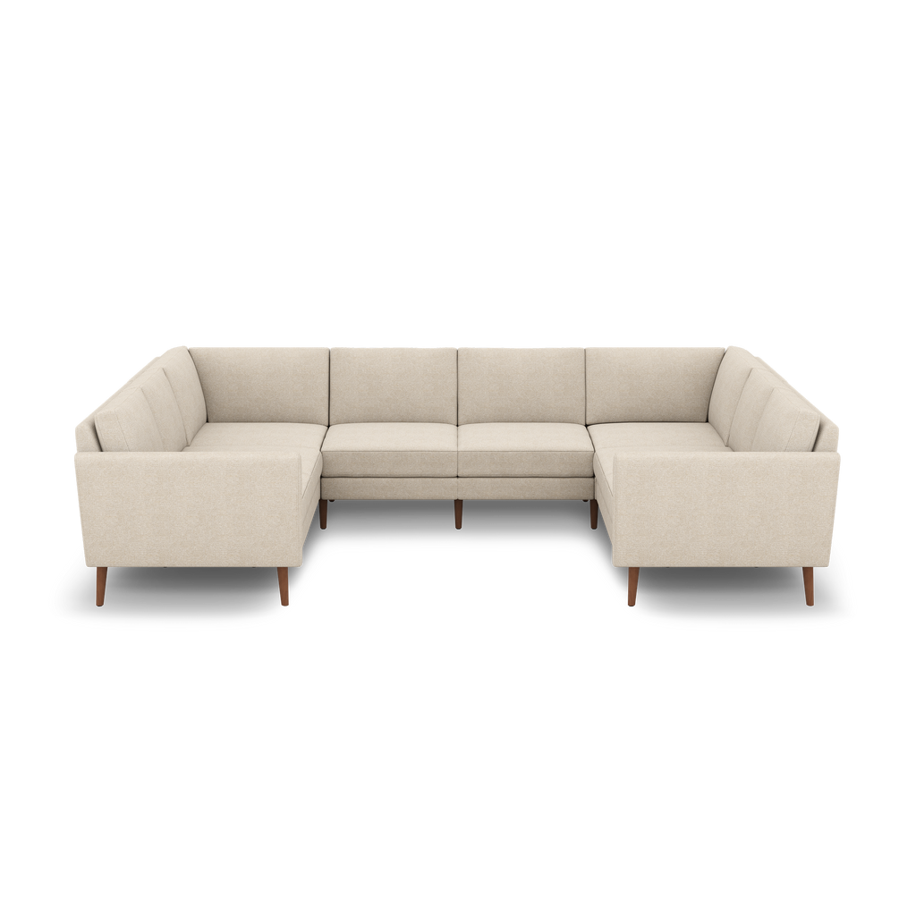 Beige fabric U-shaped sectional sofa with wooden tapered legs and cushioned backs and seats on black background.