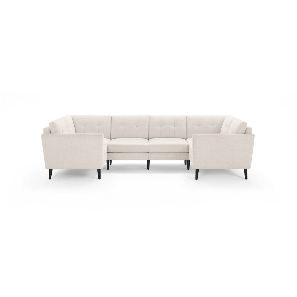 Modern U-shaped sectional sofa in light beige fabric with tufted cushions and black wooden legs, designed for spacious seating.