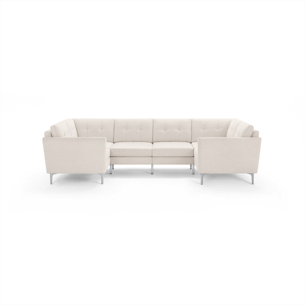 Modern U-shaped sectional sofa in light beige fabric with tufted cushions and slim metal legs, designed for spacious seating.