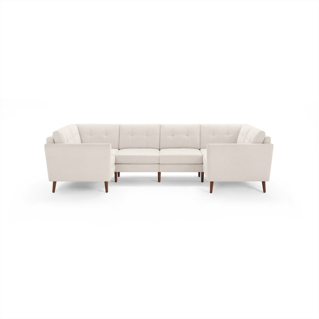 Cream-colored mid-century modern sectional sofa with tufted back cushions and wooden legs, arranged in a U-shape.
