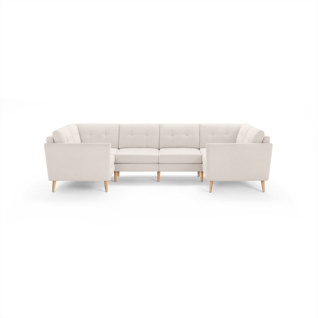 Light beige fabric U-shaped sectional sofa with tufted back cushions and wooden legs, designed for spacious seating.