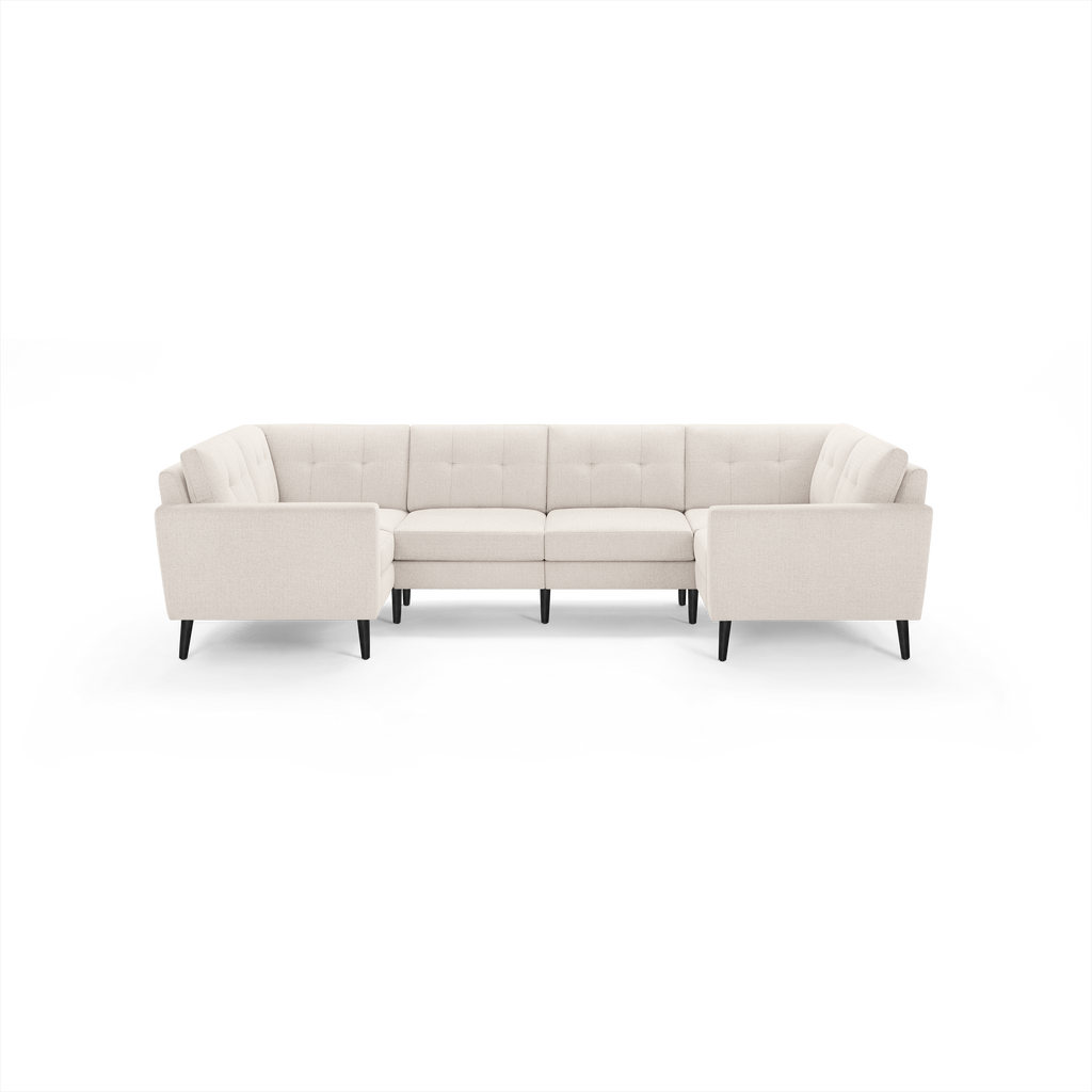 Cream-colored fabric sectional sofa with tufted back cushions and black wooden legs, arranged in a U-shape.