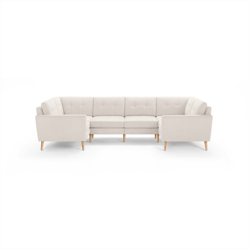 Beige fabric upholstered U-shaped sectional sofa with tufted back cushions and wooden tapered legs.