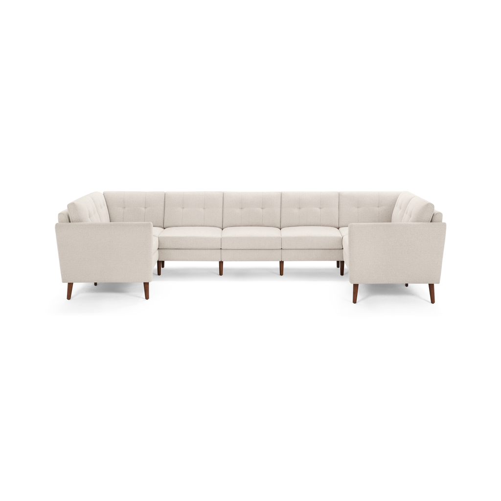 Large cream-colored sectional sofa with tufted back cushions, clean lines, and wooden legs, designed for modern living rooms.
