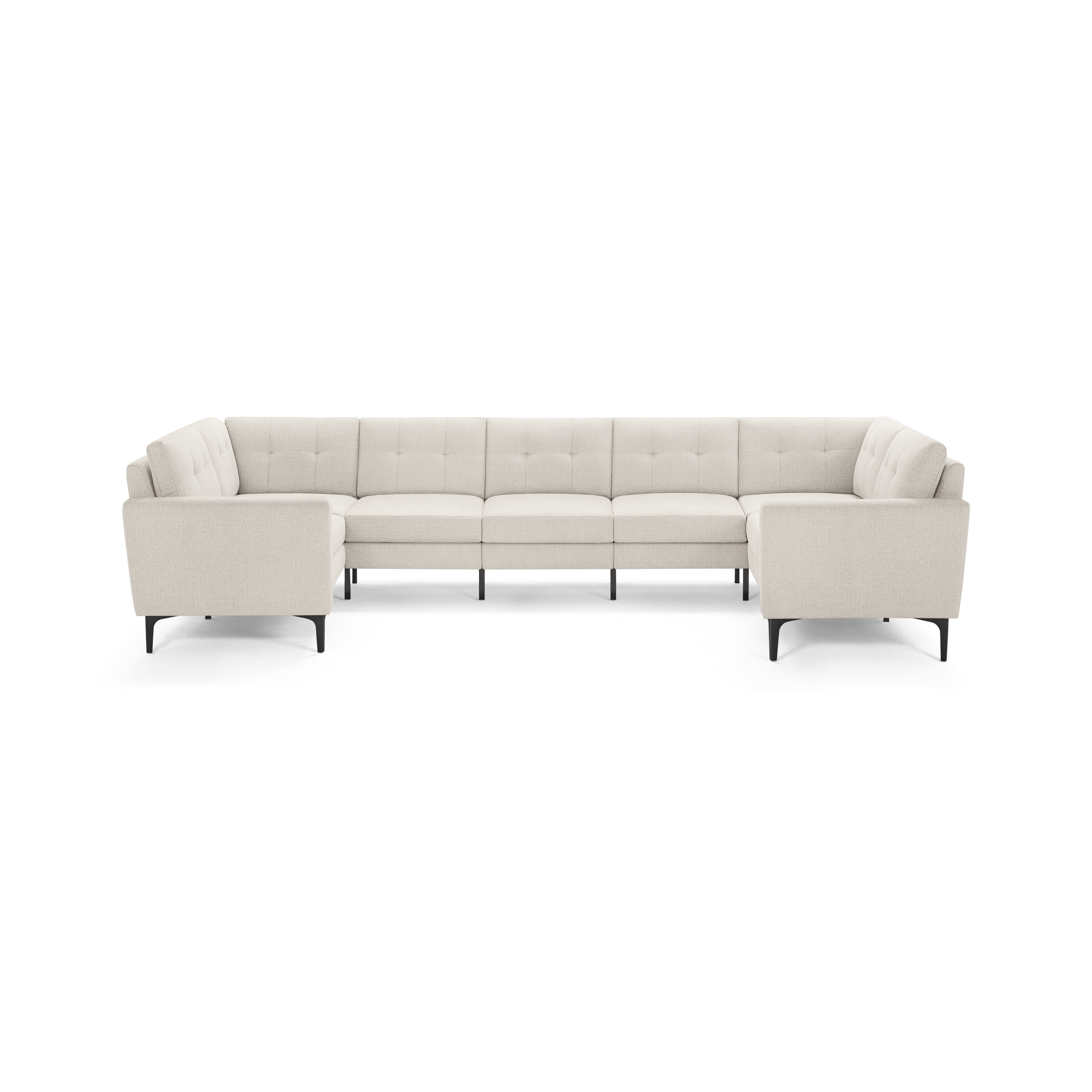 Modern large U-shaped sectional sofa upholstered in light beige fabric with tufted back cushions and slim dark legs.