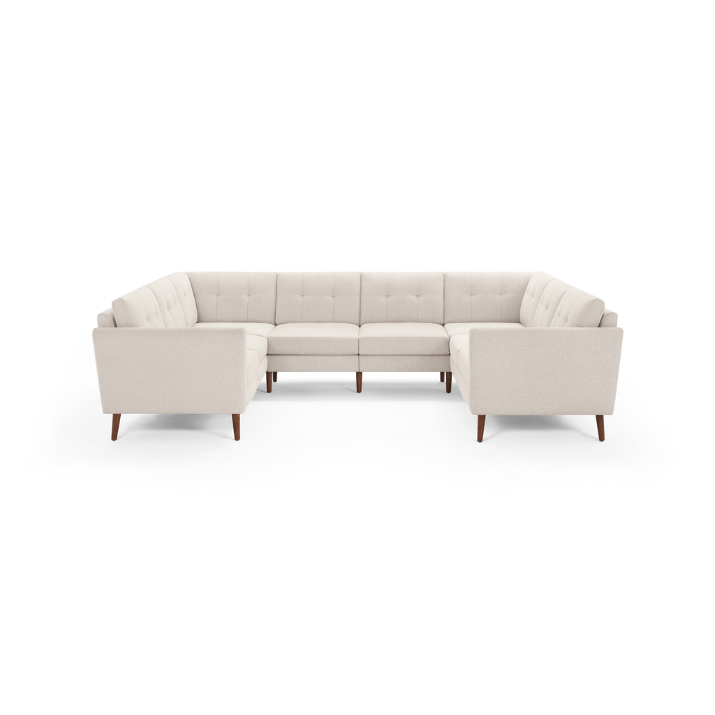 Cream-colored tufted fabric U-shaped sectional sofa with wooden legs, modern design, and cushioned seats and backs.