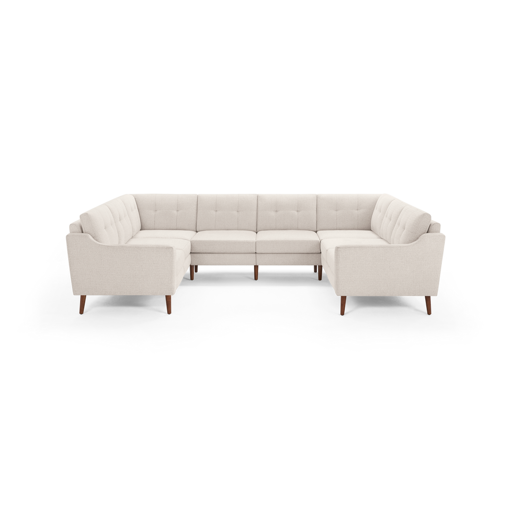 Large beige fabric U-shaped sectional sofa with tufted back cushions and wooden tapered legs, designed for spacious seating.
