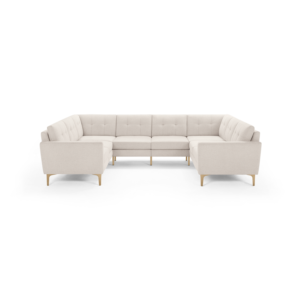 Cream-colored modern U-shaped sectional sofa with tufted back cushions and wooden tapered legs, designed for spacious seating.