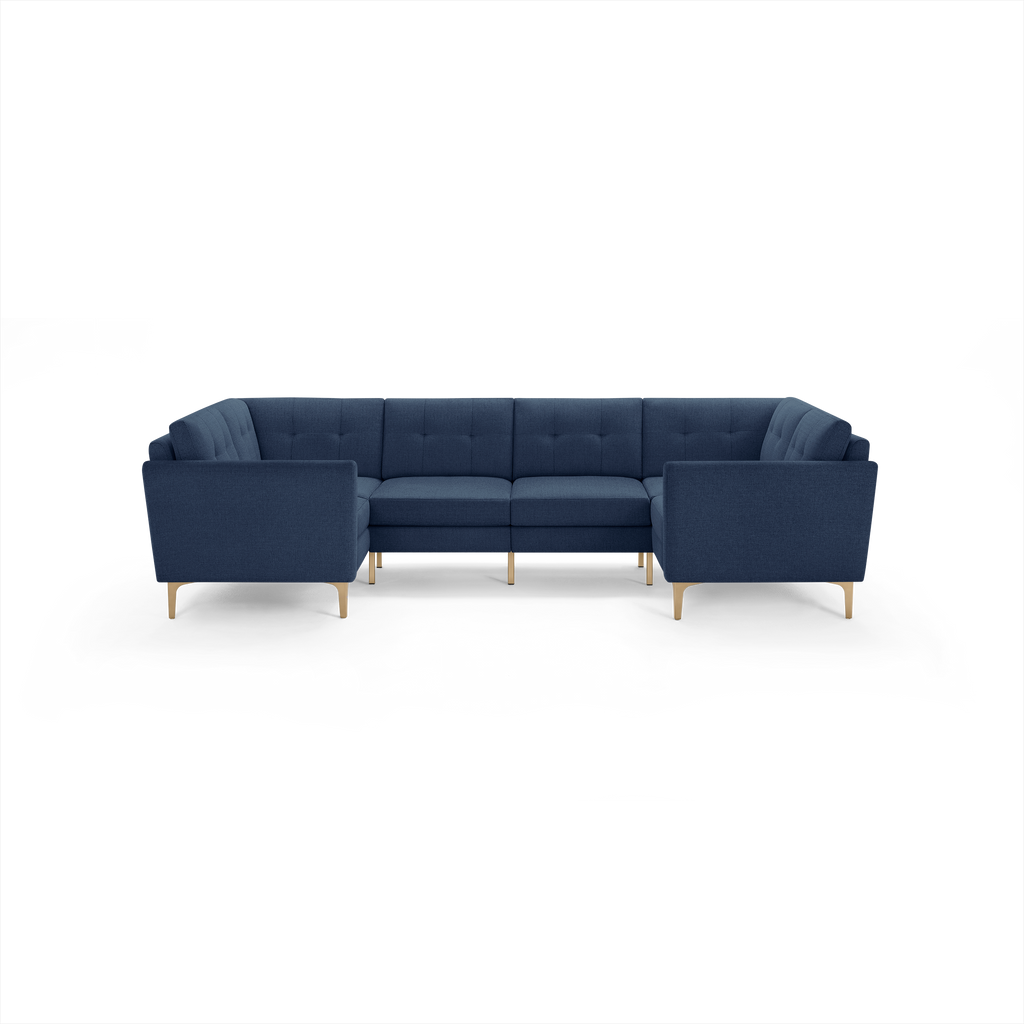 Navy blue mid-century modern sectional sofa with tufted back cushions and light wooden legs, arranged in a U-shape.