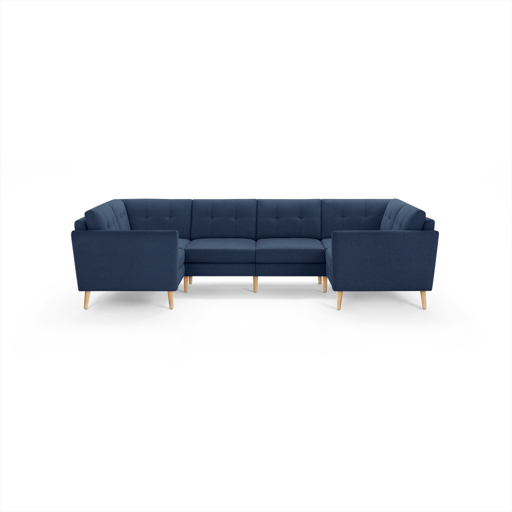 Modern navy blue fabric sectional sofa with tufted cushions and light wooden legs, featuring a U-shaped design for ample seating.