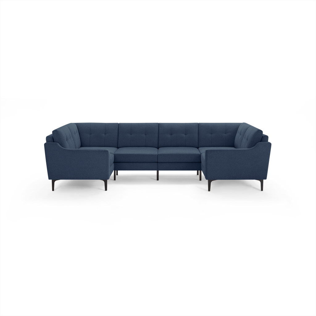 Large U-shaped sectional sofa with dark blue tufted fabric upholstery and sleek black legs, designed for modern living spaces.