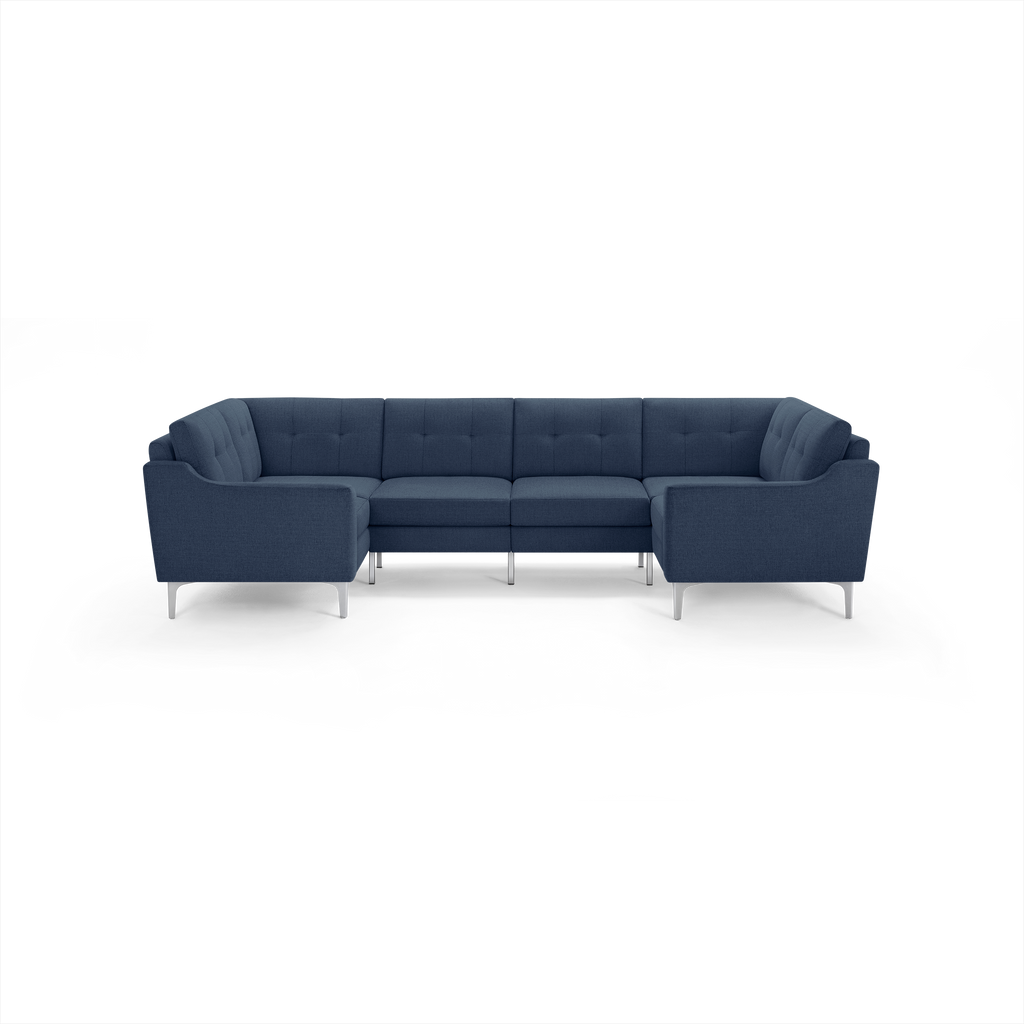 Modern navy blue U-shaped sectional sofa with tufted cushions and sleek silver legs, designed for spacious seating.