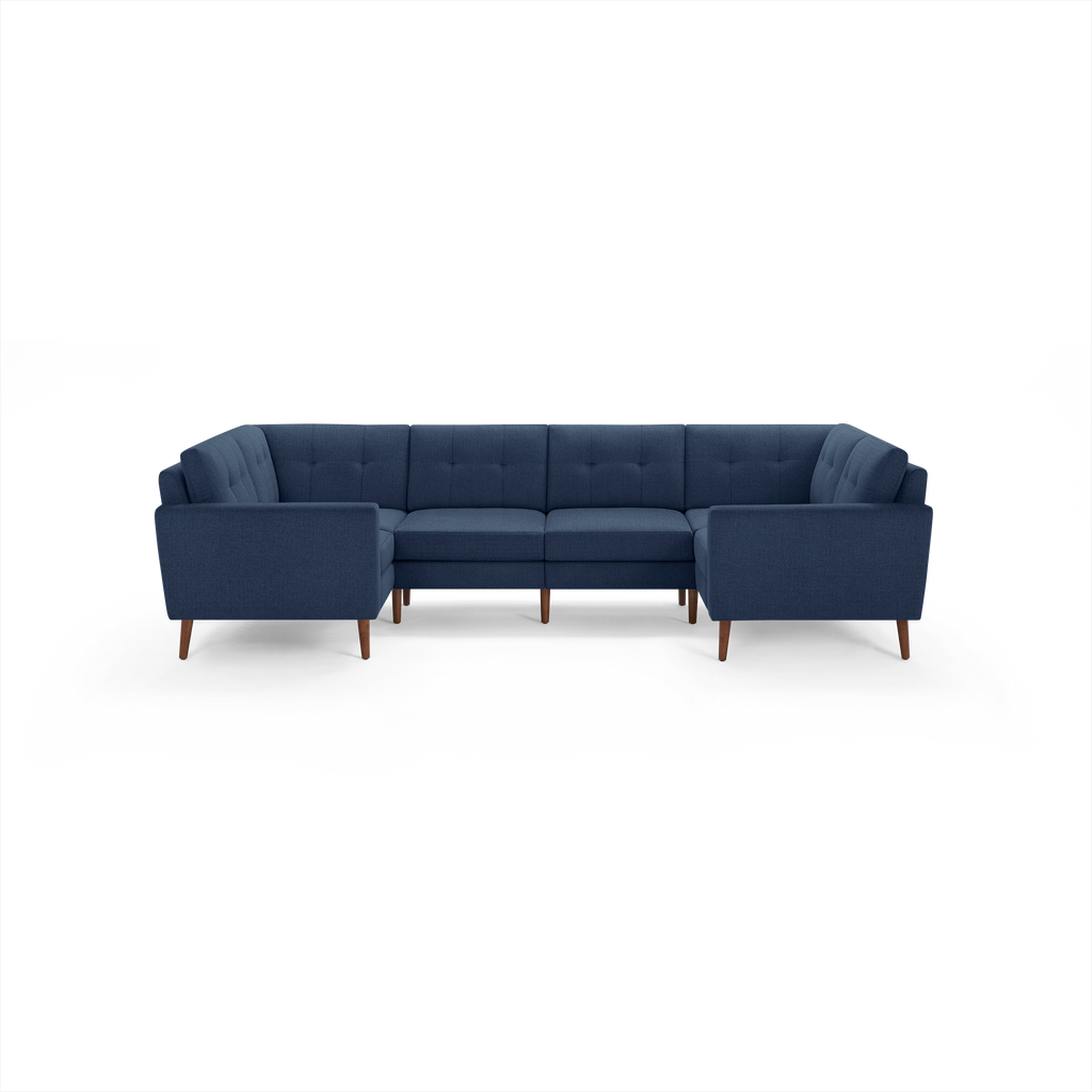 U-shaped sectional sofa in dark blue fabric with tufted cushions, wooden legs, and clean, modern design.