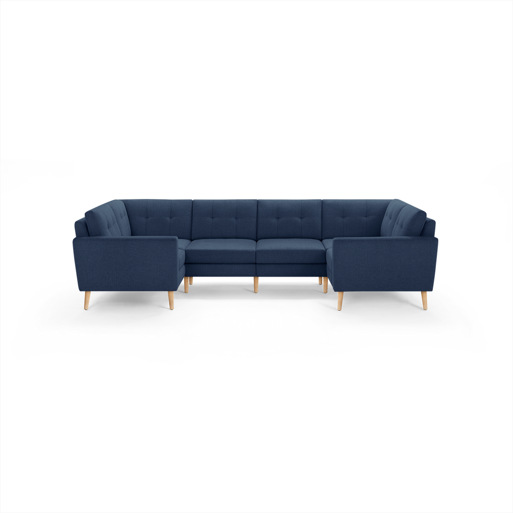 Modern navy blue sectional sofa with tufted back cushions, wooden legs, and a U-shaped design for spacious seating.