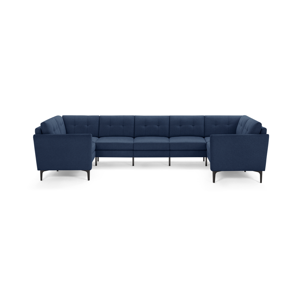 Modern navy blue upholstered U-shaped sectional sofa with tufted back cushions and slim black legs.