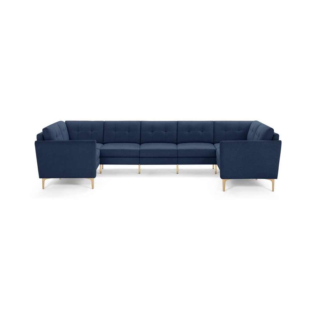 U-shaped modern sectional sofa in navy blue fabric with tufted cushions and light wooden legs.