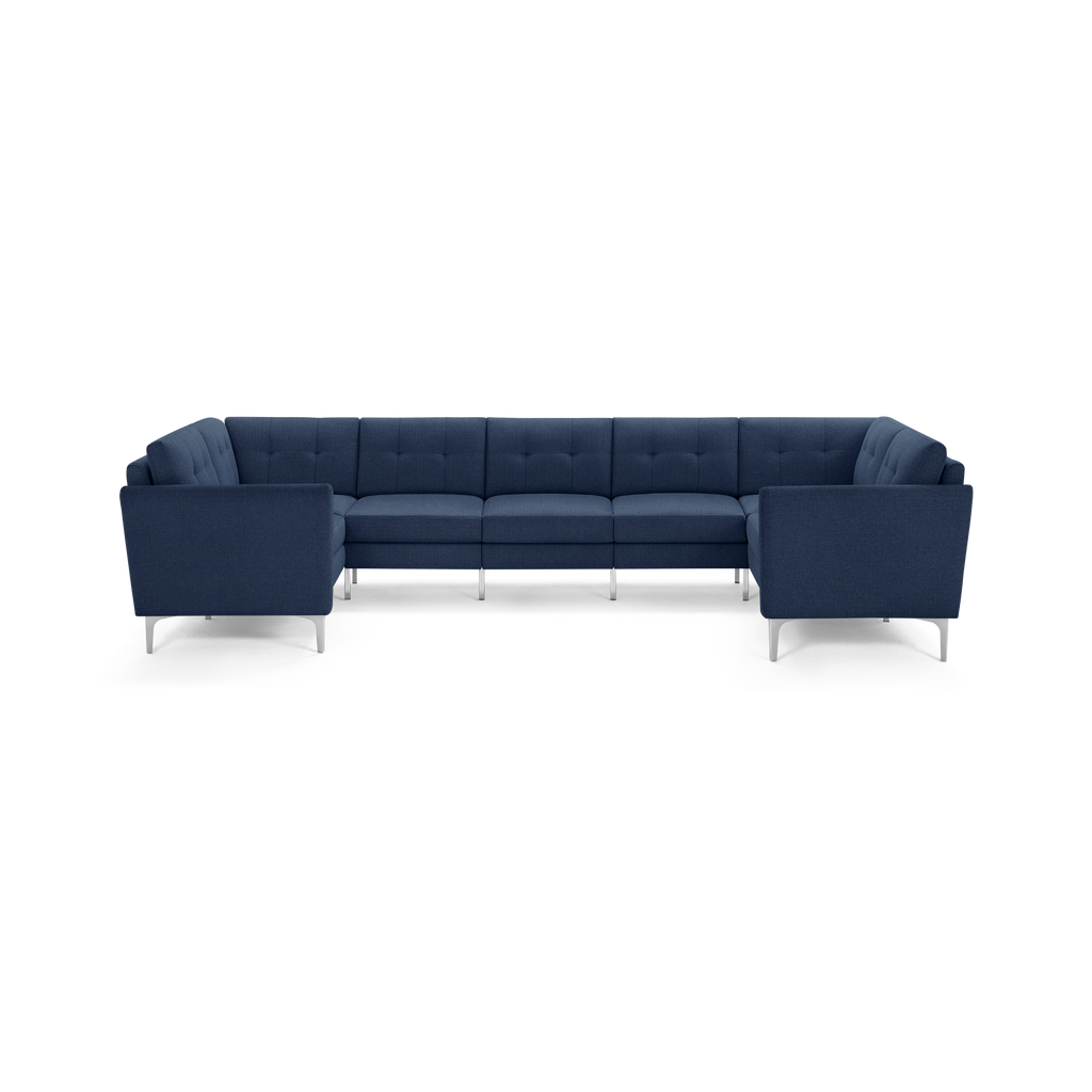 Modern L-shaped sectional sofa upholstered in dark blue fabric with tufted back cushions and sleek metal legs.