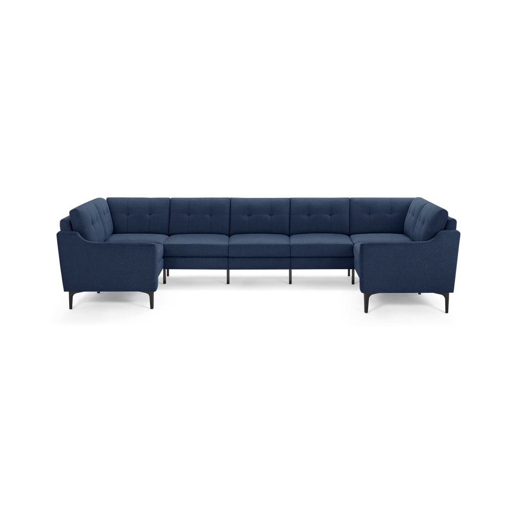Large U-shaped sectional sofa in dark blue fabric with tufted back cushions and slim black metal legs.