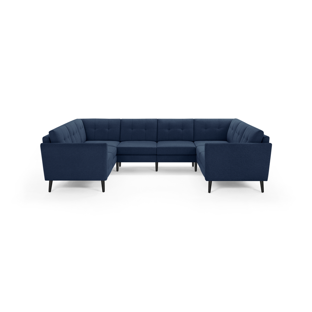 Modern navy blue U-shaped sectional sofa with tufted cushions and tapered black legs, designed for spacious seating.