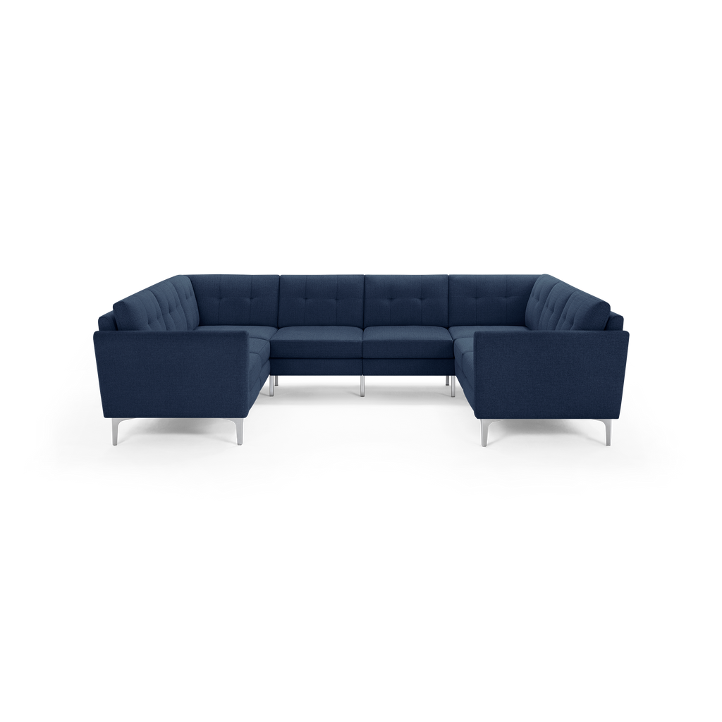 Modern U-shaped sectional sofa with navy blue fabric upholstery, tufted back cushions, and silver metal legs.