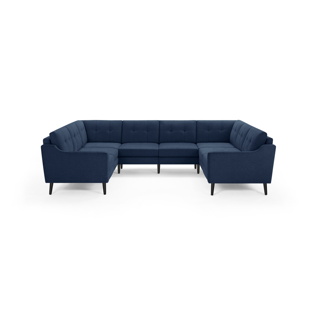 Modern navy blue fabric upholstered U-shaped sectional sofa with tufted back cushions and black tapered wooden legs.