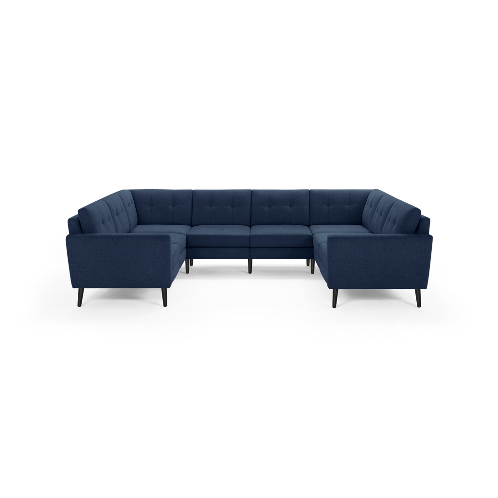 Large U-shaped sectional sofa in dark blue fabric with tufted back cushions and black tapered legs, modern and stylish design.