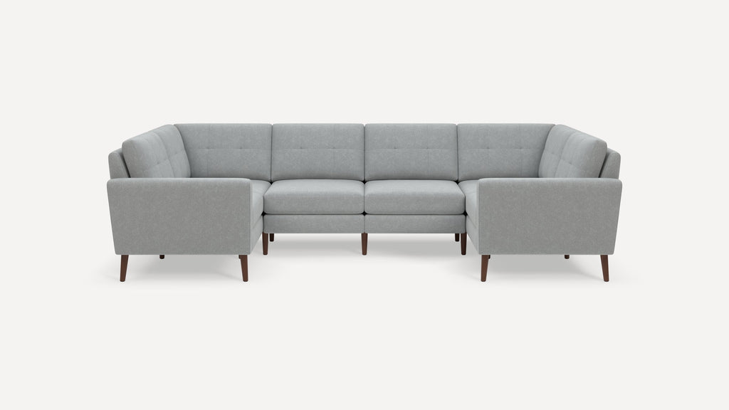 Light gray modern sectional sofa with tufted back cushions and wooden tapered legs, arranged in a U-shape.