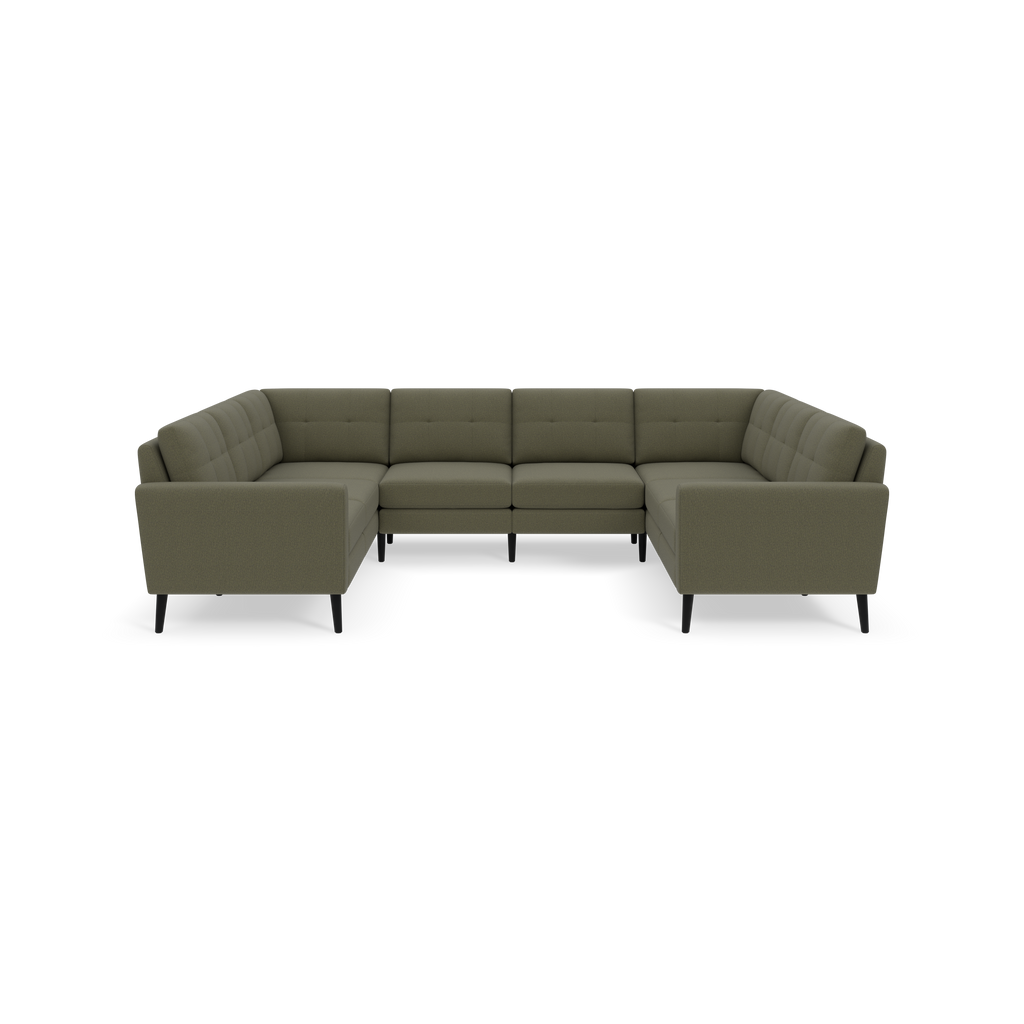 Moss green upholstered sectional sofa with tufted backrests, black legs, and an L-shaped design, isolated on black background.
