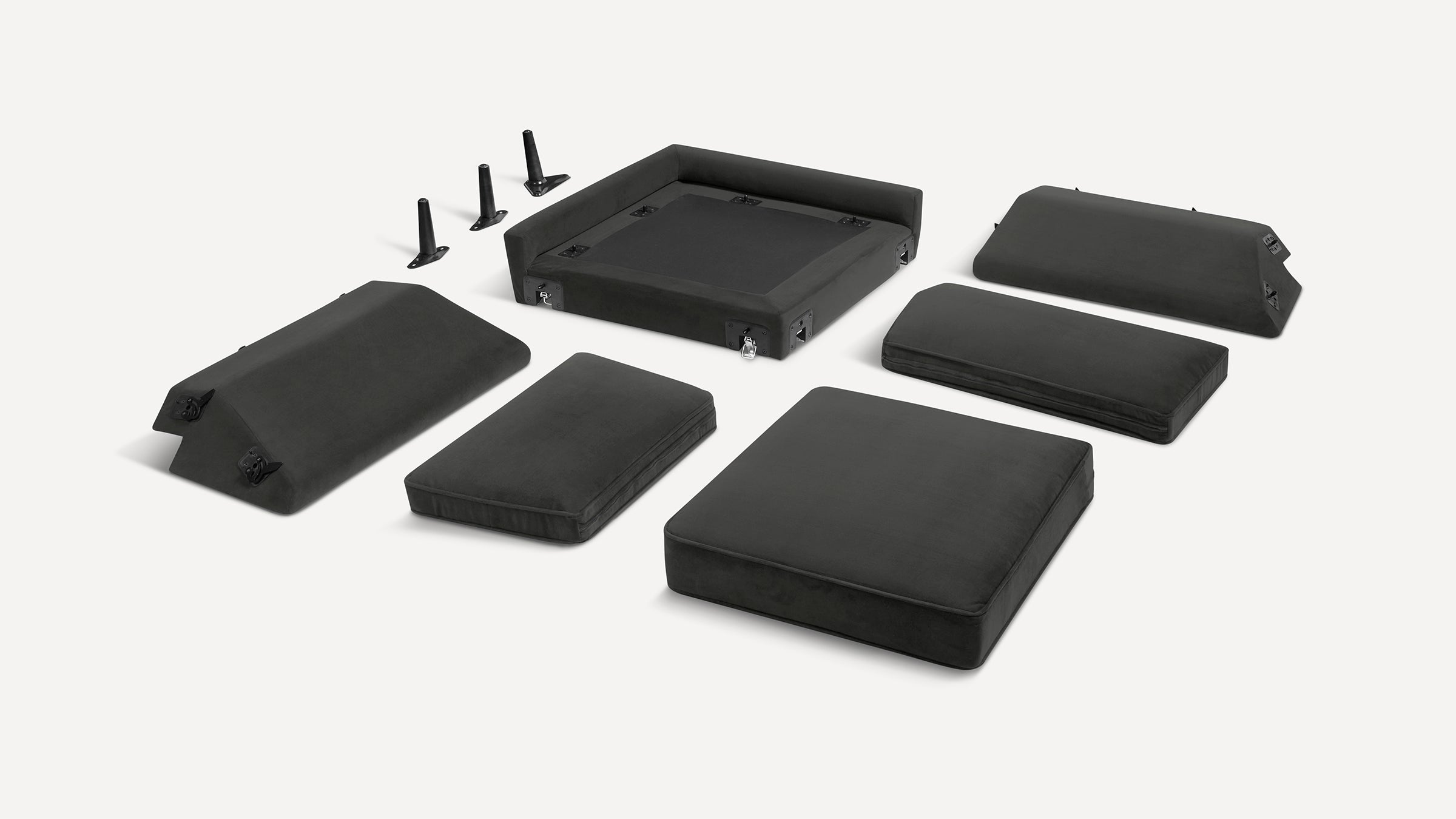 Black modular sofa cushions and components laid out separately on a white background, including base, backrests, seats, and three legs.