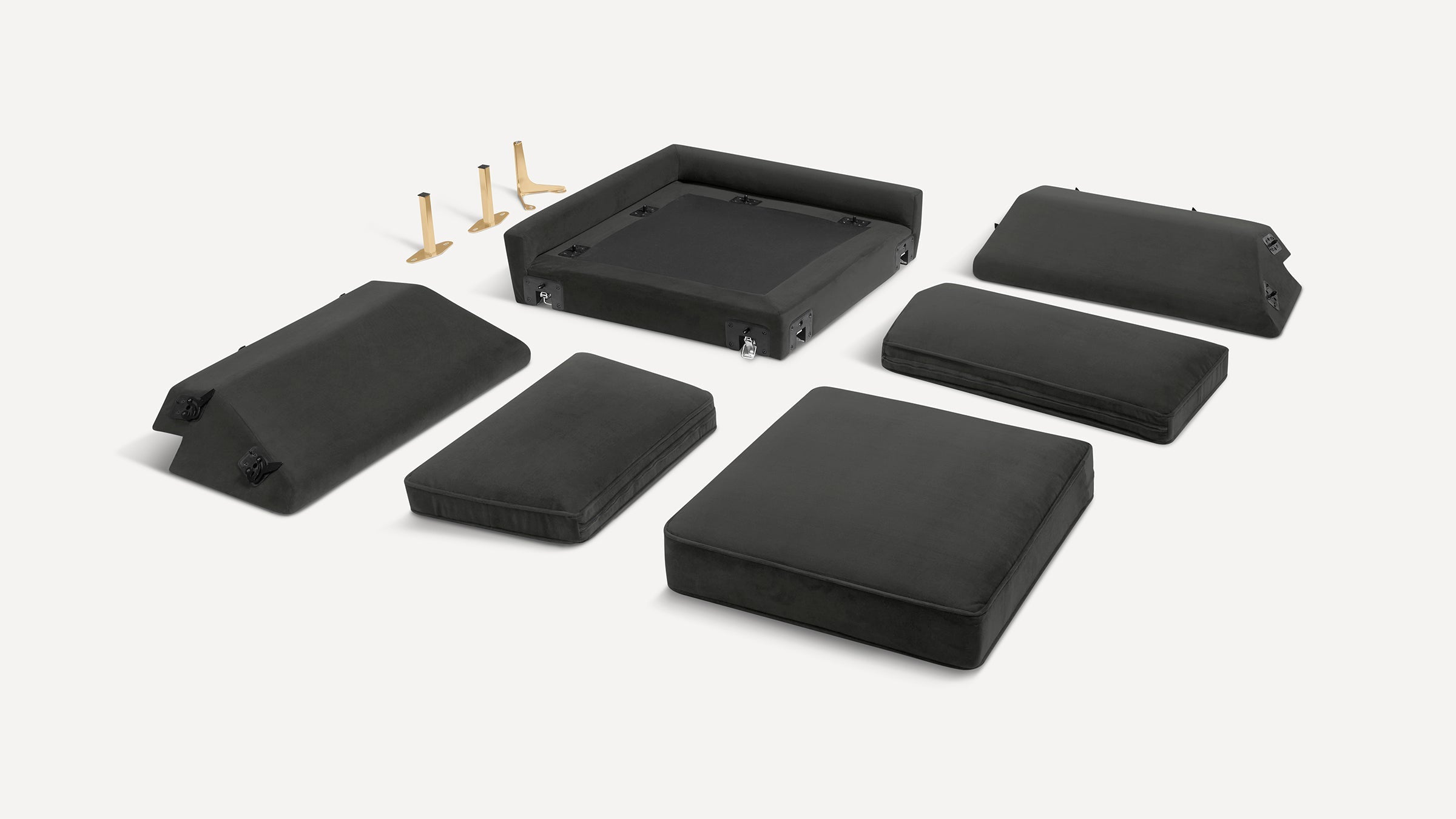 Disassembled black modular sofa or chair cushions and base components, including three gold metal legs, arranged on a white background.