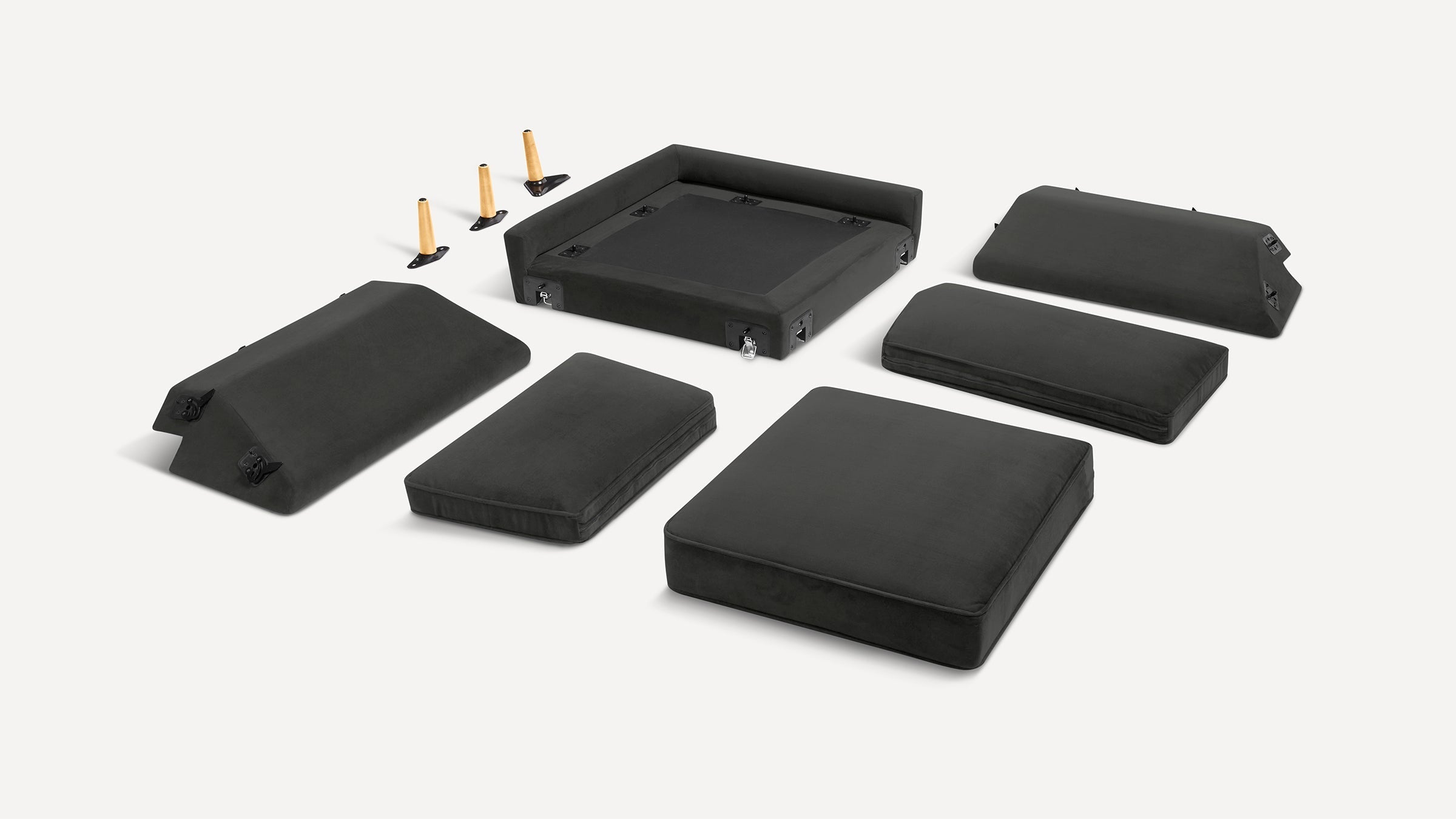 Disassembled black modular sofa components with cushions, backrests, and wooden legs arranged on a white background.