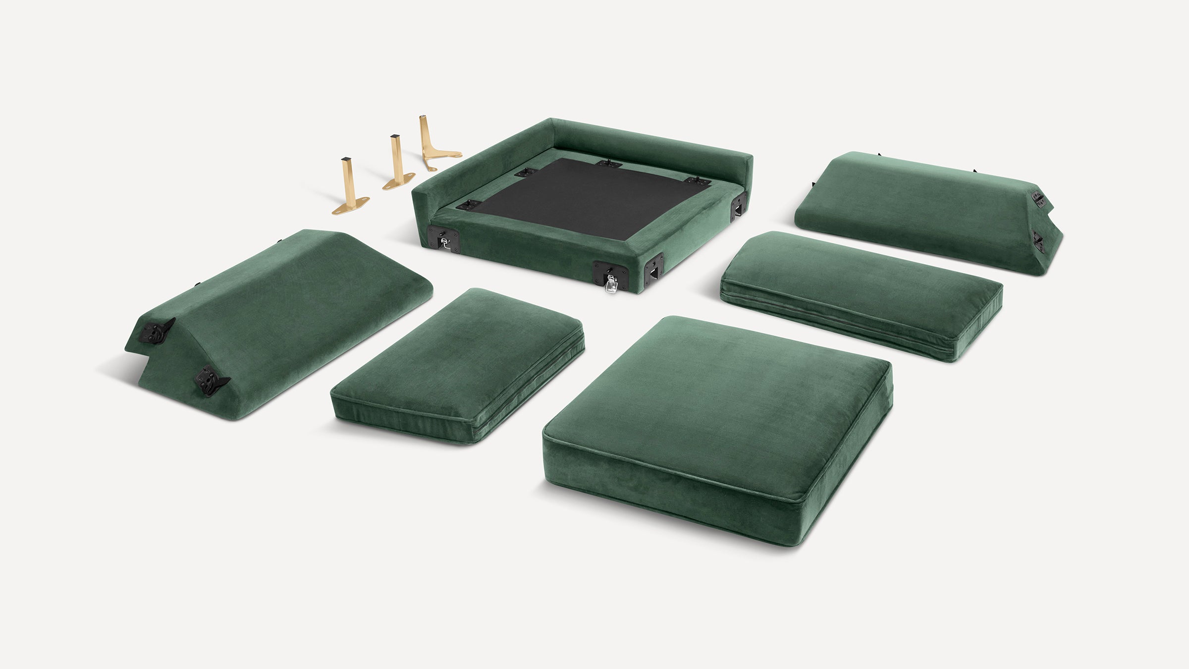 Disassembled green velvet sofa cushions and frame parts with gold metal legs, shown on a white background.