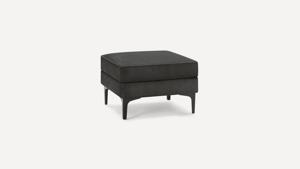 Square black upholstered ottoman with black metal legs, featuring a cushioned top and modern minimalist design.