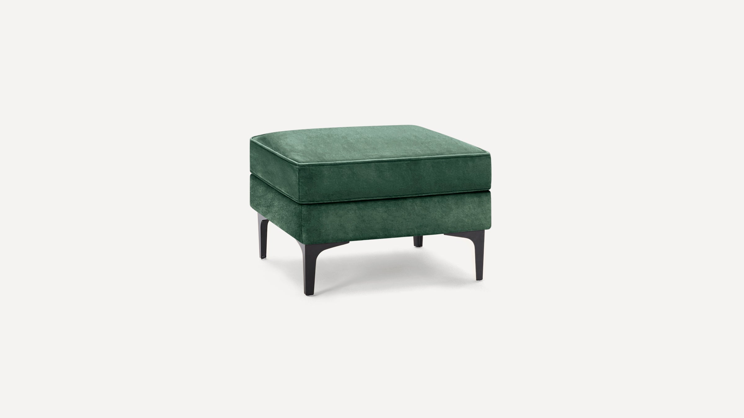 Square green velvet ottoman with black tapered legs, modern minimalist design, soft cushioned top for seating or footrest.