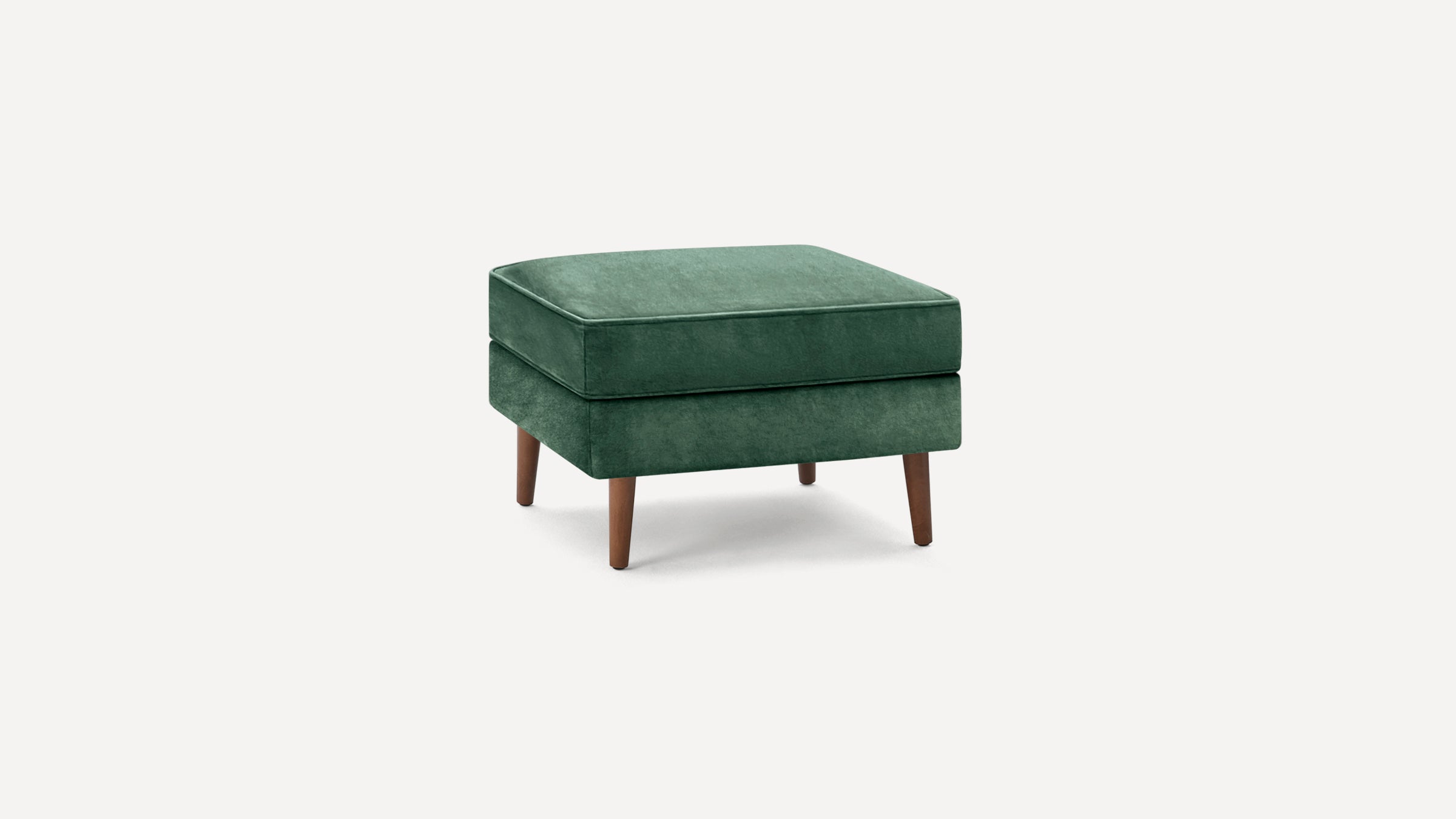 Square green velvet ottoman with wooden tapered legs, featuring a cushioned top and modern minimalist design.
