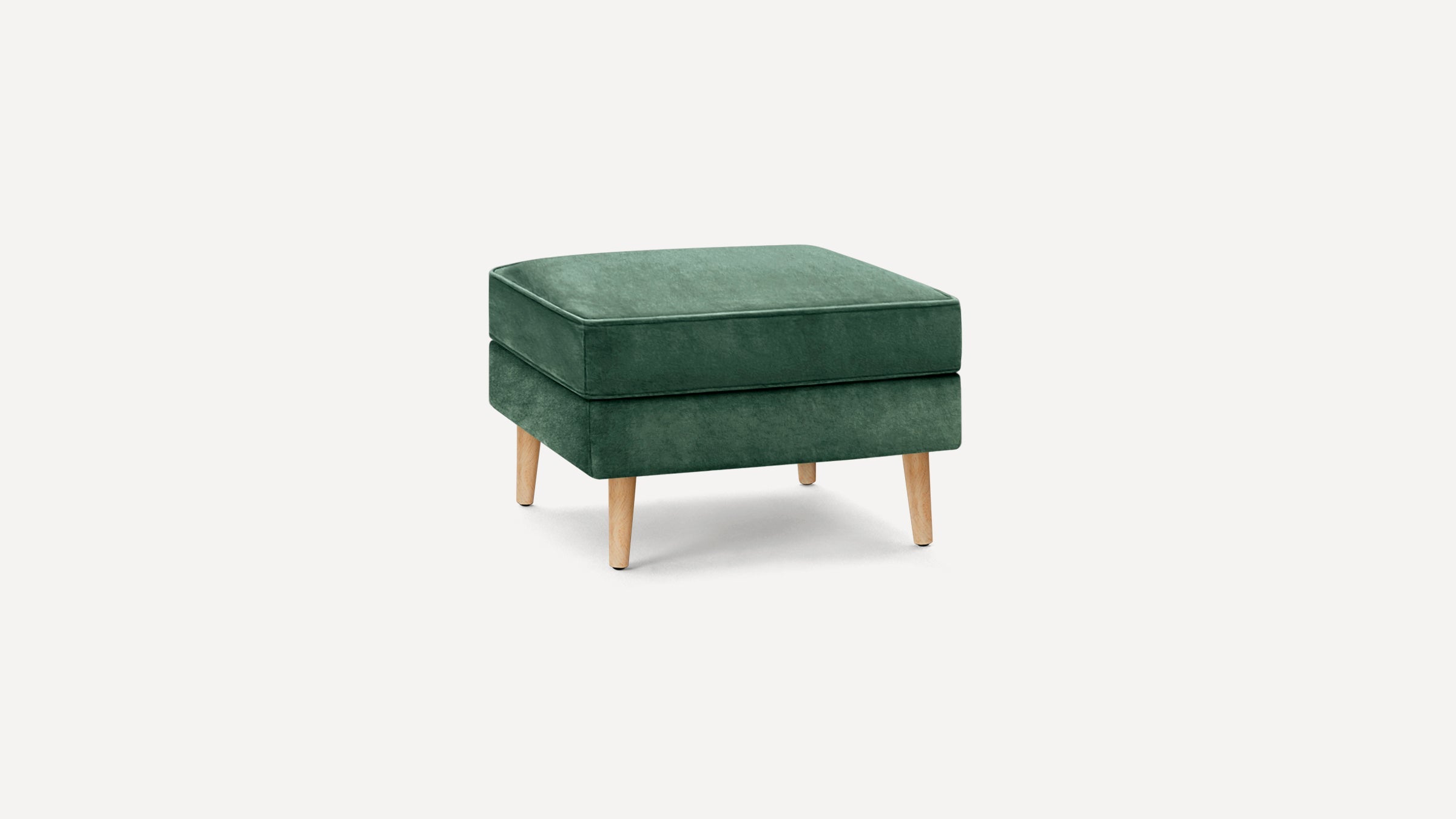 Square green velvet ottoman with wooden tapered legs, minimalist modern design, on a plain white background.
