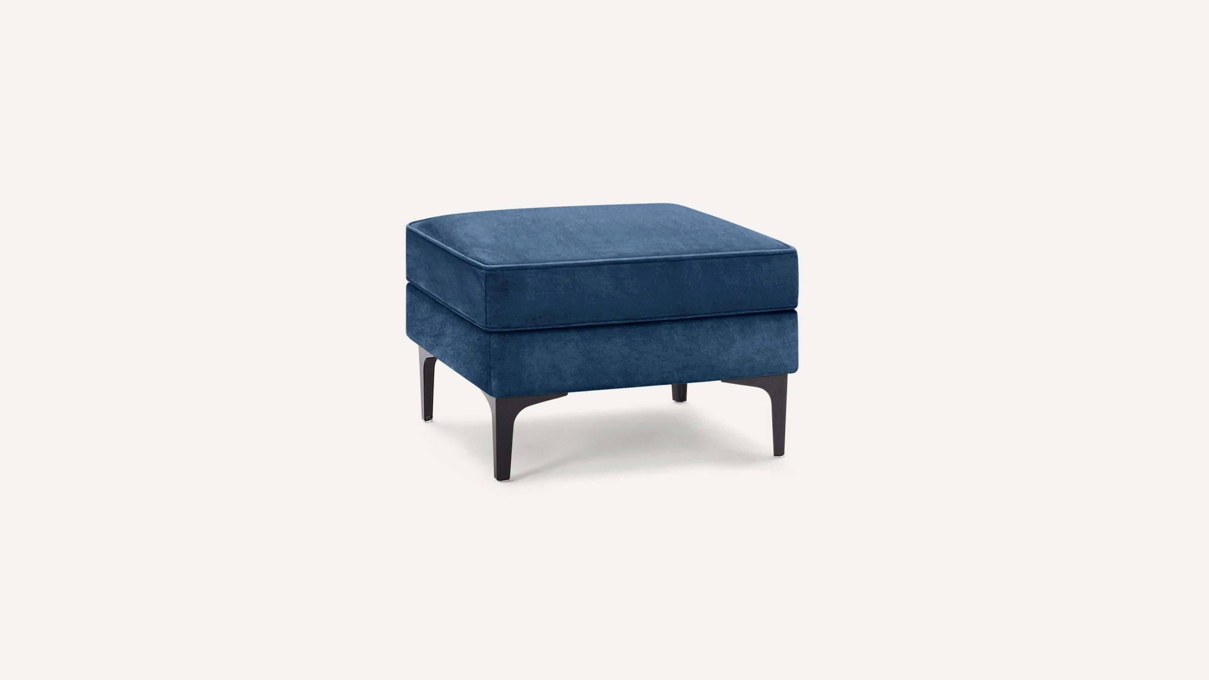 Square navy blue upholstered ottoman with black angled legs on a plain white background.