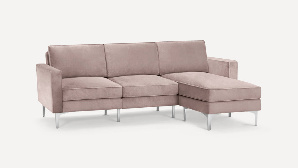 Modern light mauve velvet sectional sofa with metal legs and right-side chaise lounge on white background.