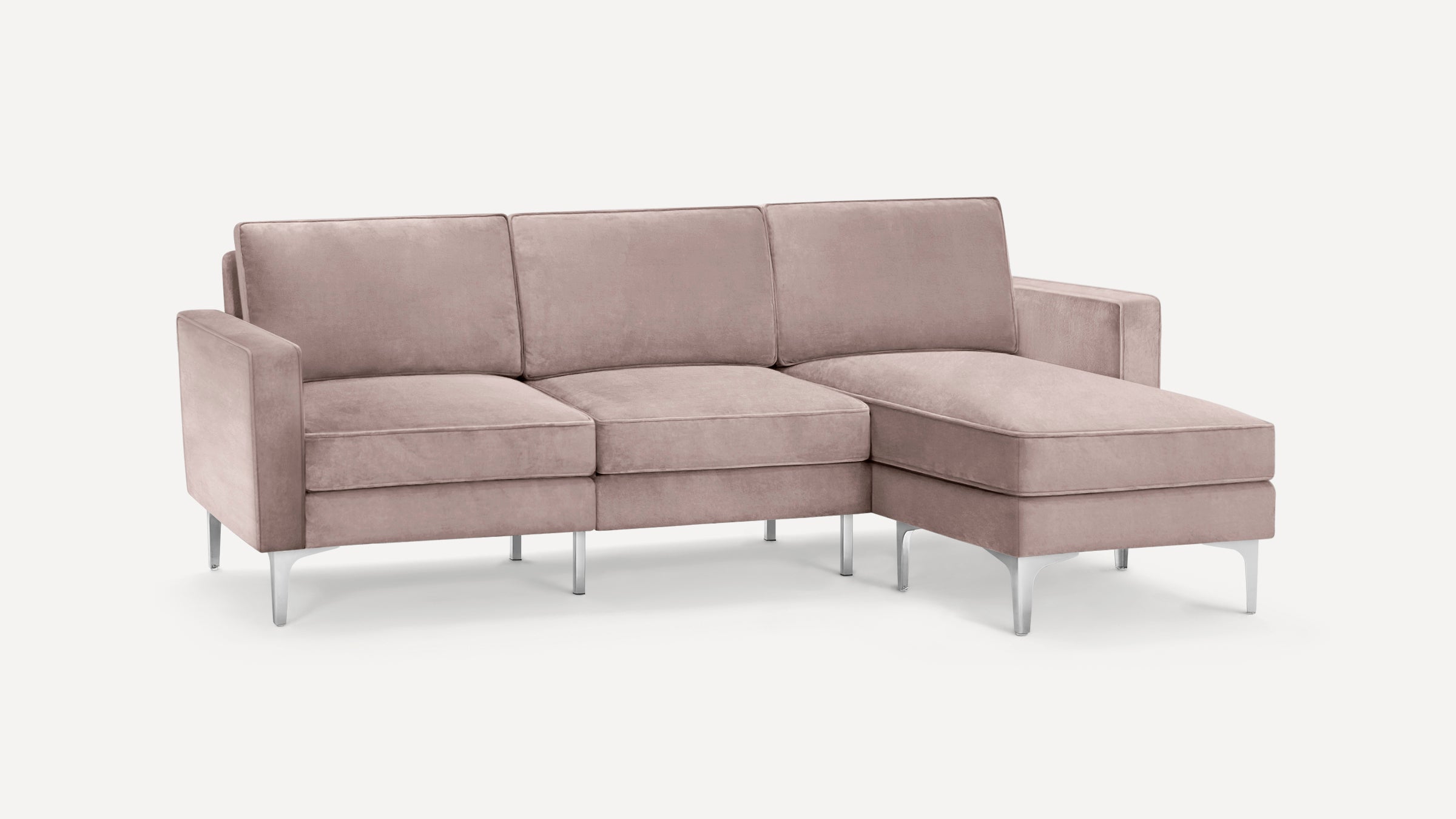 Modern light mauve velvet sectional sofa with metal legs and right-side chaise lounge on white background.
