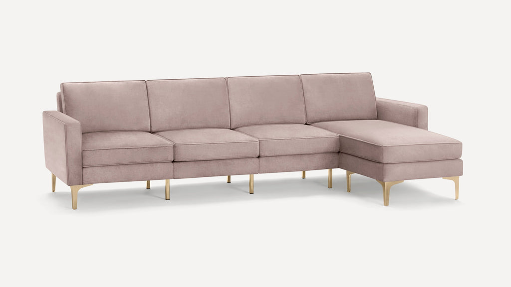 Modern sectional sofa in soft pink velvet upholstery with gold metal legs and chaise lounge on the right side.