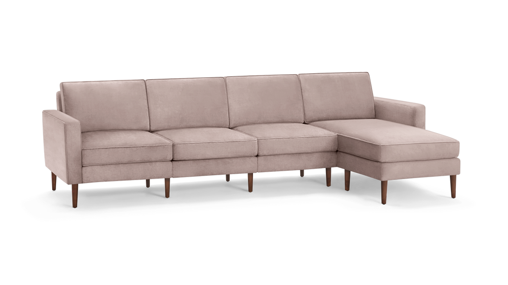 modern light pink sectional sofa with wooden legs and clean lines on the back, featuring a chaise lounge and matching ottoman