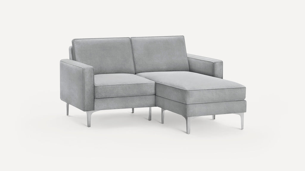 Modern light gray upholstered sectional sofa with metal legs, featuring a chaise lounge on the right side.