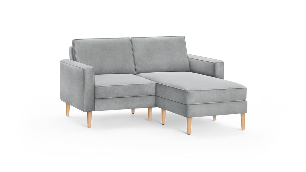 light gray modern sectional sofa with wooden legs and matching chaise lounge, featuring a clean, minimalist design