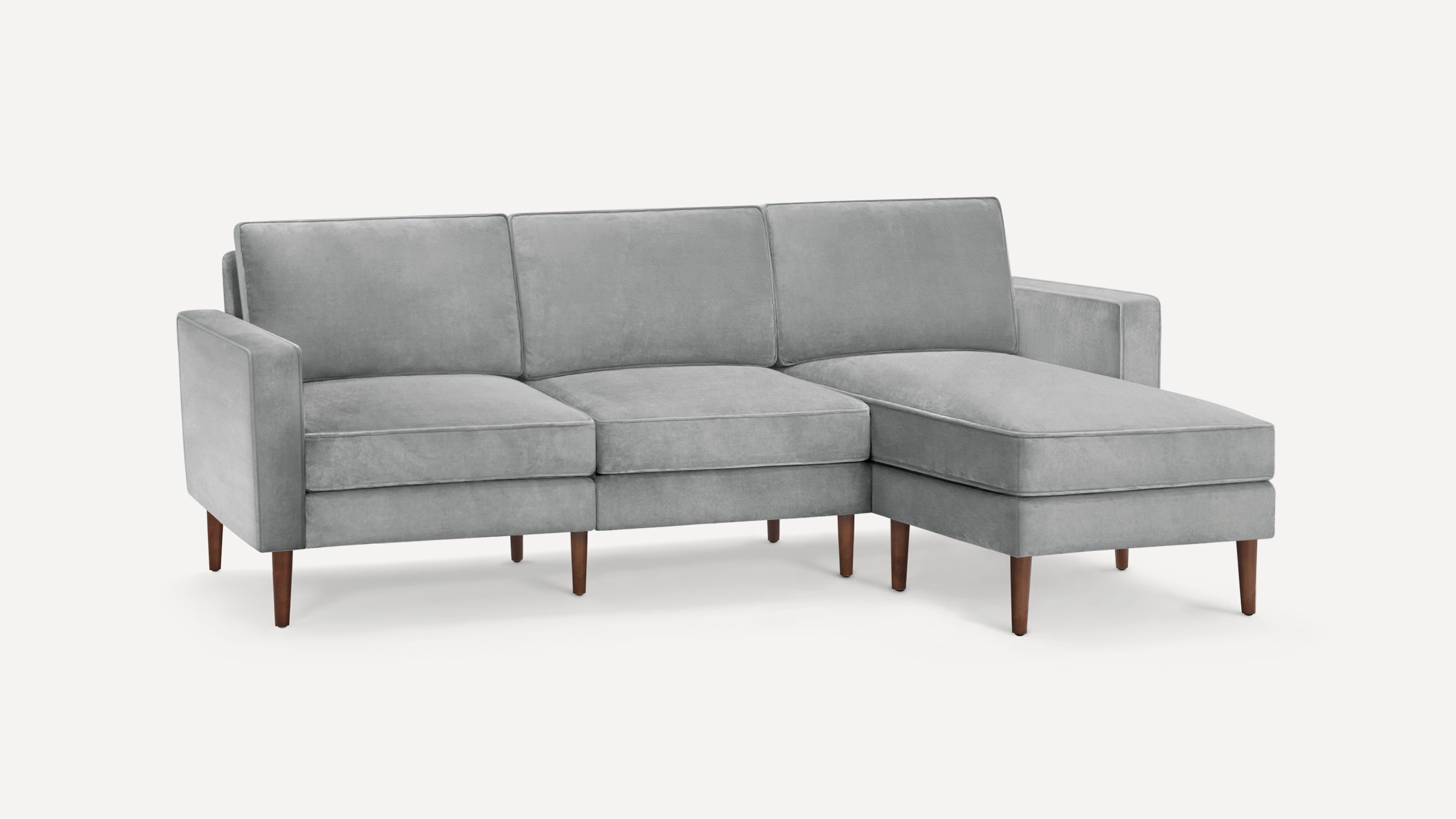 Modern gray velvet sectional sofa with clean lines, wooden tapered legs, and a right-side chaise lounge.