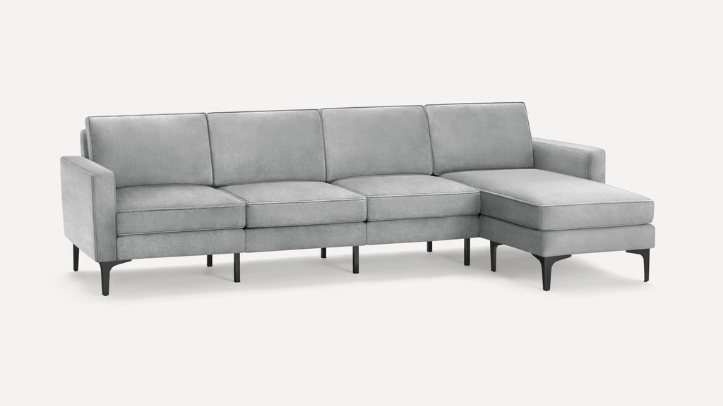 Modern light gray sectional sofa with clean lines, slim black legs, cushioned seats, and a chaise lounge on the right side.