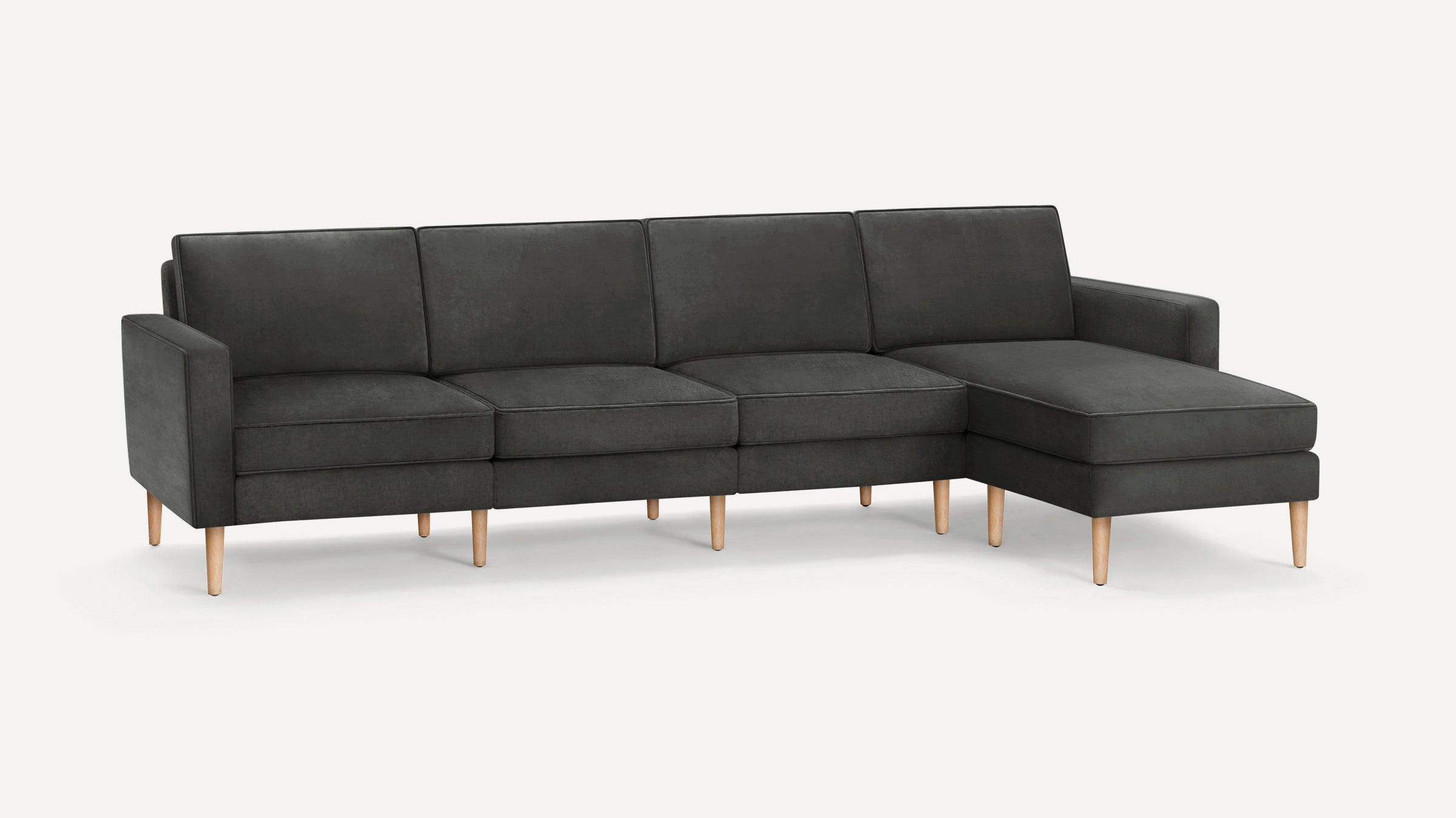Modern dark gray sectional sofa with clean lines, wooden legs, and chaise lounge on the right side, against a plain white background.