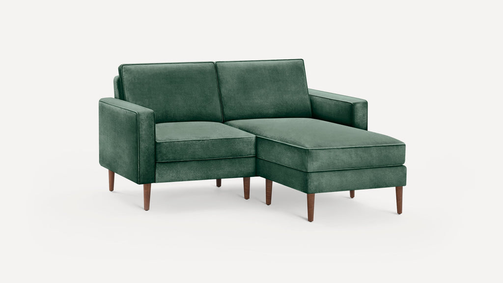 Green velvet sectional sofa with wooden legs, featuring a right-side chaise lounge and clean, modern lines.